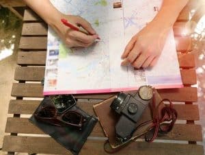 Person learning how to plan a trip by using a map to pick the itinerary.